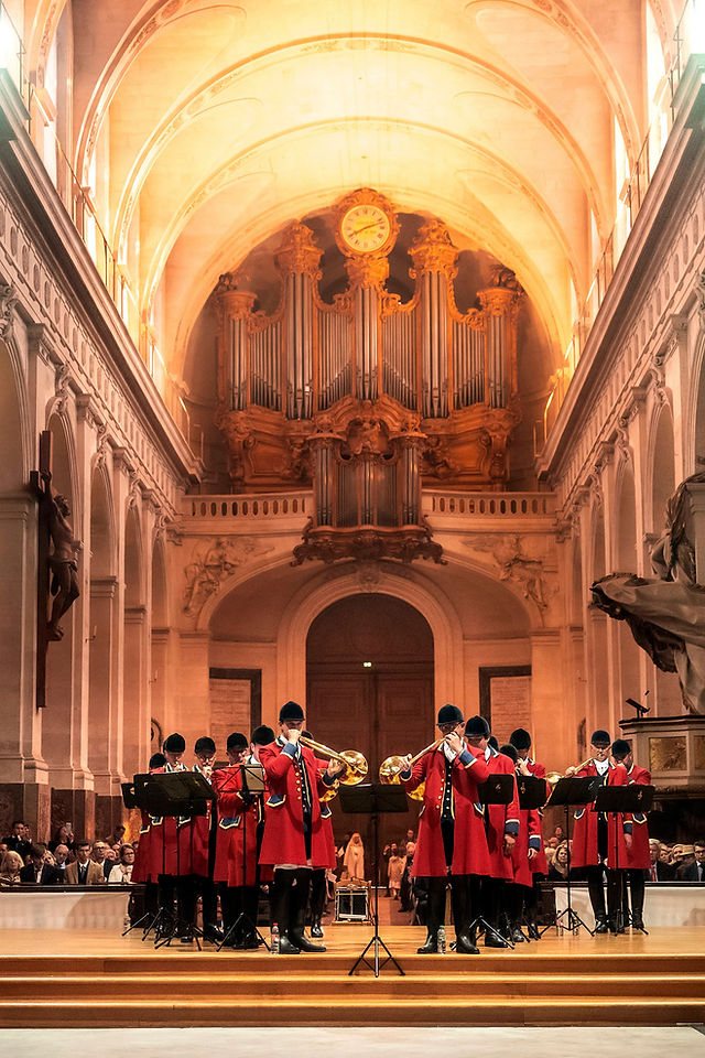 Les sonneurs du Débuché de Paris en demi-cercle devant le grand orgue d'une église