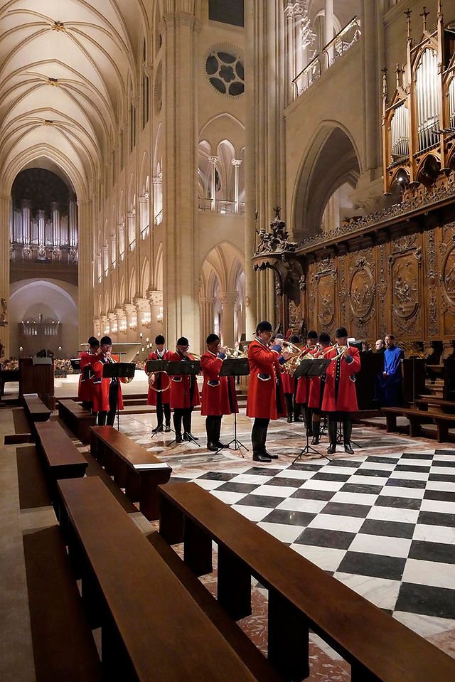 Les sonneurs alignés dans le chœur de Notre-Dame de Paris, la nef gothique et les orgues derrière eux