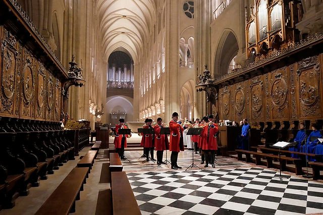 Le Débuché de Paris sonnant dans le chœur de Notre-Dame de Paris, sur le dallage en damier, devant les stalles de bois